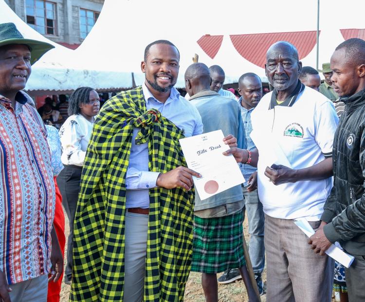 Lands Principal Secretary Generali Nixon Koriri issues title deed to a resident of Churo/Amaya Ward in Tiaty Constituency.